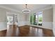 Refined dining room features a large window, elegant chandelier, and hardwood floors at 605 Tatum Ct, Alpharetta, GA 30022