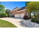 Brick home showcasing a three-car garage with a spacious driveway at 605 Tatum Ct, Alpharetta, GA 30022