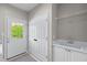Laundry area with sink, cabinets, wire shelving, and access to exterior door at 605 Tatum Ct, Alpharetta, GA 30022