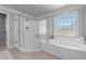 Bright bathroom with stand up shower, soaking tub, and decorative window with a view at 605 Tatum Ct, Alpharetta, GA 30022