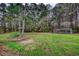 Large backyard featuring mature trees and a chicken coop, offering ample space for outdoor activities at 1277 Bethany Rd, Covington, GA 30016