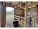 View of a barn stall, equipped with wooden fencing and bucket at 1277 Bethany Rd, Covington, GA 30016