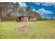 Exterior of barn on a sunny day with a horse, great for rural living or animal enthusiasts at 1277 Bethany Rd, Covington, GA 30016