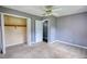 This carpeted bedroom features an open closet, ceiling fan, and gray painted walls at 1277 Bethany Rd, Covington, GA 30016