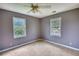 Neutral bedroom with carpet, neutral walls, two windows, and a ceiling fan at 1277 Bethany Rd, Covington, GA 30016