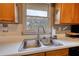 Kitchen with stainless steel double sink and wooden cabinets with a view of the outdoors from the window at 1277 Bethany Rd, Covington, GA 30016