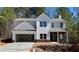 Two-story home featuring stone accents, a two-car garage, and a combination of lap siding and gable details at 16 Deer Place, Villa Rica, GA 30180