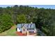 Aerial view of a two-story home with a front porch, nestled among lush green trees at 208 Wellington Walk, Douglasville, GA 30134