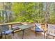 Outdoor deck with seating and a table, offering a relaxing view of the surrounding woods at 208 Wellington Walk, Douglasville, GA 30134
