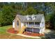 Charming two-story home with stone accents, dormers, a front porch, a lush lawn, and mature trees at 208 Wellington Walk, Douglasville, GA 30134