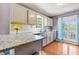 Kitchen with granite countertops, white cabinets, and natural light streaming through the window at 208 Wellington Walk, Douglasville, GA 30134