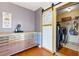 Functional laundry room with sliding barn door, stainless steel washer/dryer, and ample cabinet space at 208 Wellington Walk, Douglasville, GA 30134