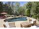 Inviting backyard oasis featuring a private pool surrounded by lush landscaping and comfortable patio seating at 3025 Greenfield Dr, Marietta, GA 30068