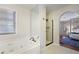 Bright bathroom showcasing a modern shower with glass door and soaking tub with access to main bedroom at 3025 Greenfield Dr, Marietta, GA 30068