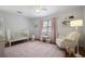 Cozy bedroom with a white crib, rocking chair, plush rug, and bright natural light at 3025 Greenfield Dr, Marietta, GA 30068