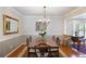 Elegant dining room featuring a chandelier, wainscoting detail, hardwood floors, and seating for eight at 3025 Greenfield Dr, Marietta, GA 30068