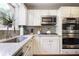 Bright kitchen featuring stainless steel appliances, white cabinetry and gray backsplash, offering a stylish and functional space at 3025 Greenfield Dr, Marietta, GA 30068