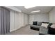 Finished basement area with a cozy sectional couch, neutral carpet, and multiple doors at 489 Warrenton Dr, Douglasville, GA 30134