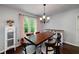 Dining room features a window, chandelier, and white cabinet adding charm and natural light at 489 Warrenton Dr, Douglasville, GA 30134