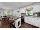 Bright kitchen with white cabinets, an island, and stainless steel appliances provides an eat-in breakfast area at 489 Warrenton Dr, Douglasville, GA 30134