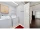 Bright laundry area featuring modern washer, dryer, cabinet storage, and wire shelving for optimal organization at 489 Warrenton Dr, Douglasville, GA 30134