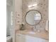 Stylish bathroom with patterned wallpaper, a round mirror, and a granite vanity at 1038 Huntcliff, Atlanta, GA 30350