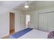 Bright bedroom featuring a ceiling fan, closet, and doorway leading to an upstairs area with wood flooring at 1038 Huntcliff, Atlanta, GA 30350