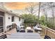 A multi-level back deck features an outdoor dining area, seating, and views of the mature trees at 1295 Lindenwood Ne Ln, Brookhaven, GA 30319