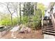 Backyard view of a wood deck, stairs, a fenced yard, mature trees, and flowering bushes at 1295 Lindenwood Ne Ln, Brookhaven, GA 30319