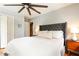 A bright bedroom features a tufted headboard, white bedding, a ceiling fan, and a closet at 1295 Lindenwood Ne Ln, Brookhaven, GA 30319