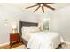A gray bedroom with a large bed, a ceiling fan, hardwood floors, and a window with natural light at 1295 Lindenwood Ne Ln, Brookhaven, GA 30319