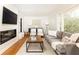 Cozy living room showcasing a modern fireplace, gray sofa, and ample natural light at 1295 Lindenwood Ne Ln, Brookhaven, GA 30319