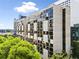Exterior view of a high-rise building with expansive windows, multiple balconies, and mature trees in the foreground at 145 15Th Ne St # 435, Atlanta, GA 30309