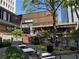 Outdoor space with dining tables, chairs, lush greenery, and buildings in the background at 145 15Th Ne St # 435, Atlanta, GA 30309