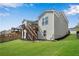 The house has a spacious backyard with green lawn and a wooden staircase to the upper level at 244 Walnut Ridge Rd, Canton, GA 30115