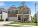 Two-story brick home featuring an attached two-car garage, landscaped yard, and a cozy front porch at 244 Walnut Ridge Rd, Canton, GA 30115