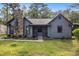 Inviting home featuring a prominent stone chimney, landscaped front yard, and covered entry way at 285 Independence Dr, Jonesboro, GA 30238