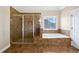A bathroom features a glass shower, tile floor, jacuzzi, and a bright window at 400 Icicle Ct, Hampton, GA 30228