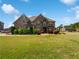 Beautiful two-story brick home with a lush green lawn and manicured landscaping at 400 Icicle Ct, Hampton, GA 30228