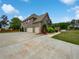 Exterior angle view shows a brick home with a three-car garage and a well-manicured lawn at 400 Icicle Ct, Hampton, GA 30228