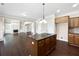 Open-concept kitchen with an island cooktop flowing into a living space with a fireplace and built-in shelves at 400 Icicle Ct, Hampton, GA 30228