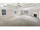 This main bedroom has a tray ceiling, fireplace, large carpeted floor, and many windows at 400 Icicle Ct, Hampton, GA 30228