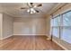 Spacious bedroom featuring hardwood floors, a fan, and window at 6273 Clapham Ln, Johns Creek, GA 30097