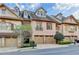 Charming brick townhome featuring a two-car garage, and mature landscaping at 6273 Clapham Ln, Johns Creek, GA 30097