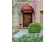 Elegant entryway featuring a stained wood double door and a decorative red awning at 6273 Clapham Ln, Johns Creek, GA 30097