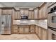 Gourmet kitchen featuring granite countertops, stainless steel appliances, and custom cabinetry at 6273 Clapham Ln, Johns Creek, GA 30097