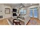 Spacious living room featuring a stone fireplace, a ceiling fan, and natural light at 6273 Clapham Ln, Johns Creek, GA 30097