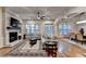 Bright living room featuring hardwood floors, a decorative fireplace, and ample natural light at 6273 Clapham Ln, Johns Creek, GA 30097