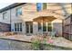 Inviting stone patio with umbrella, chairs, and manicured garden view at 6273 Clapham Ln, Johns Creek, GA 30097