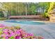 Community pool surrounded by mature trees and blooming flowers at 6273 Clapham Ln, Johns Creek, GA 30097